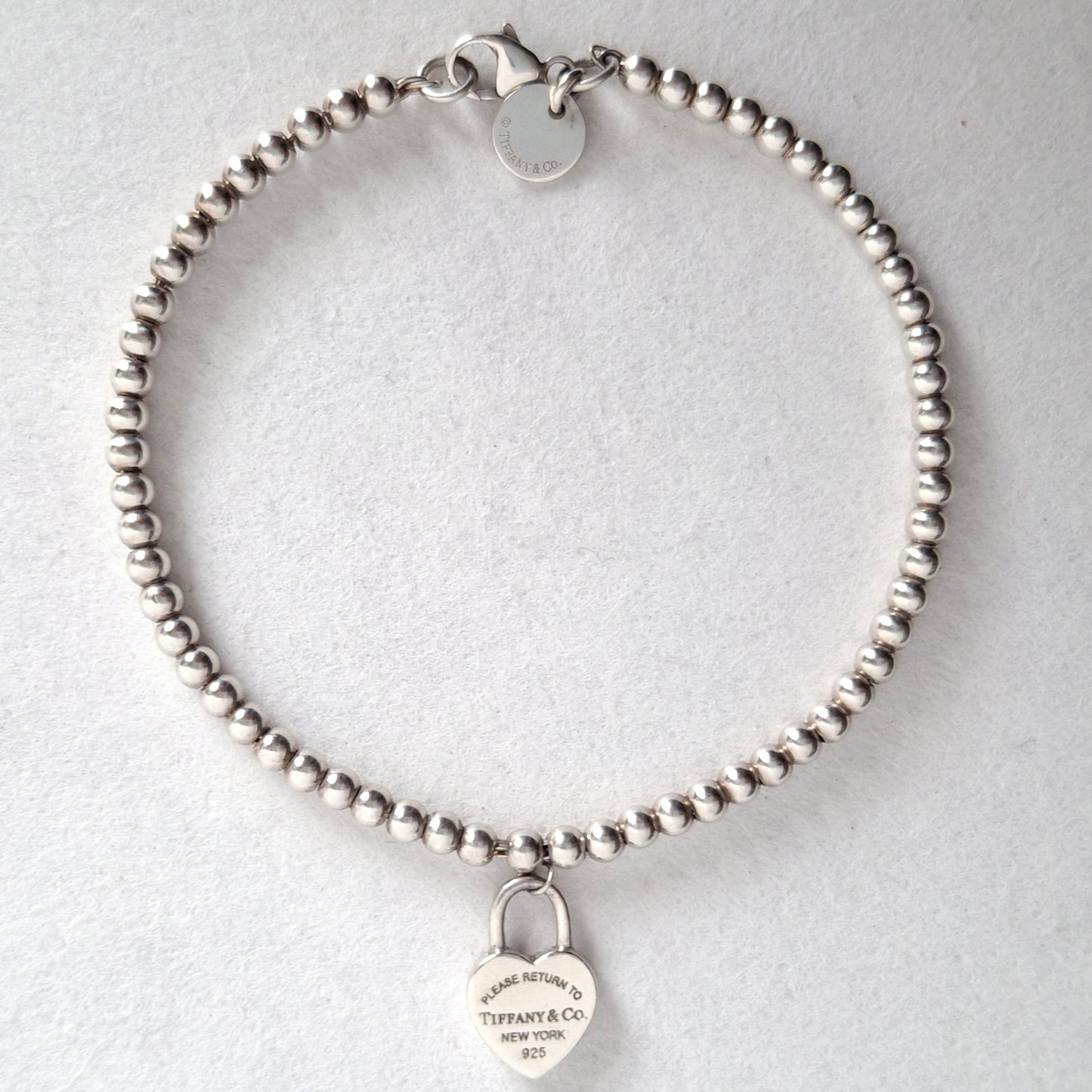 Return to Tiffany & Co 3mm Bead Bracelet with Mini Heart Padlock Charm
