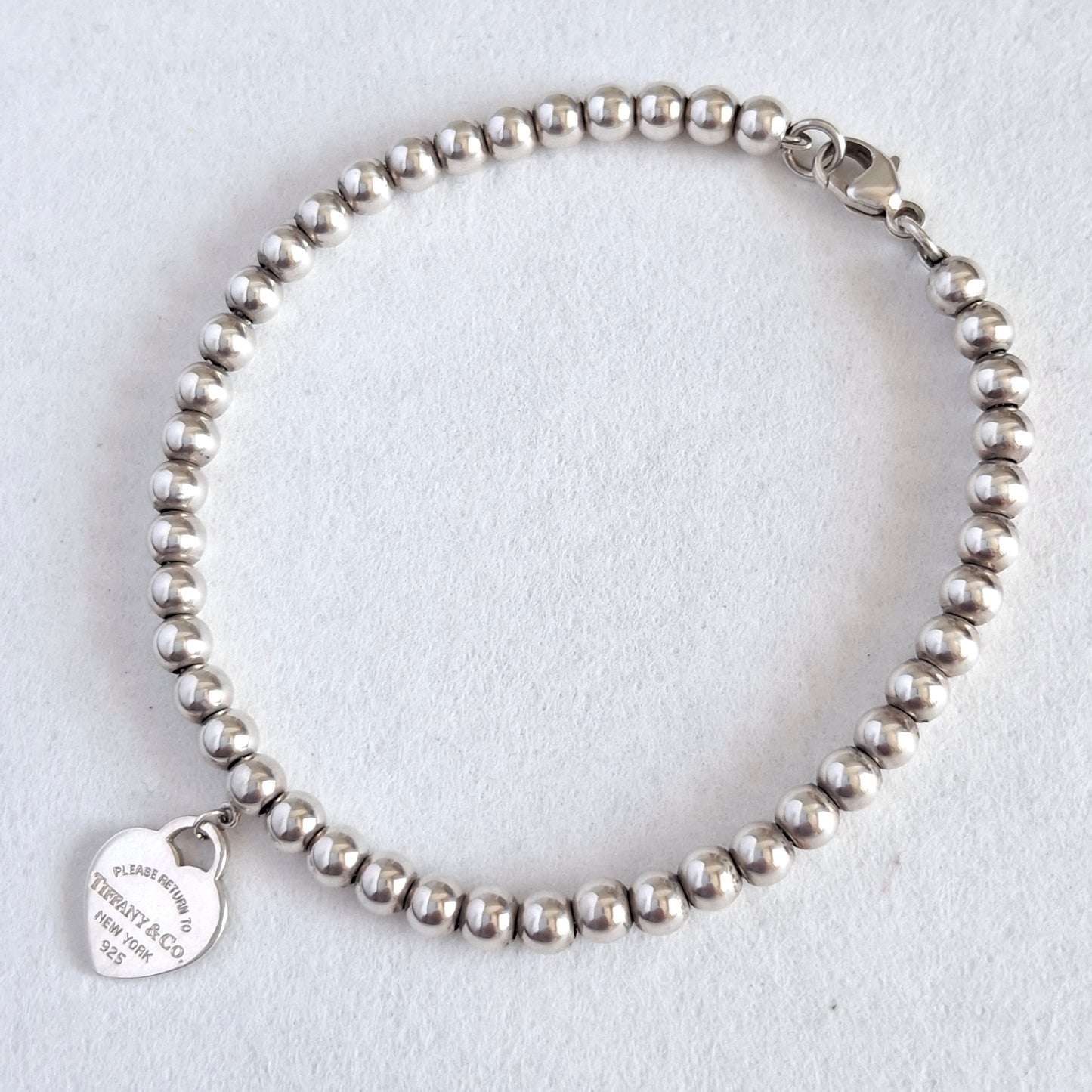 Return to Tiffany & Co 3mm Bead Bracelet with 10mm Blue Enamel Heart Charm in Sterling Silver